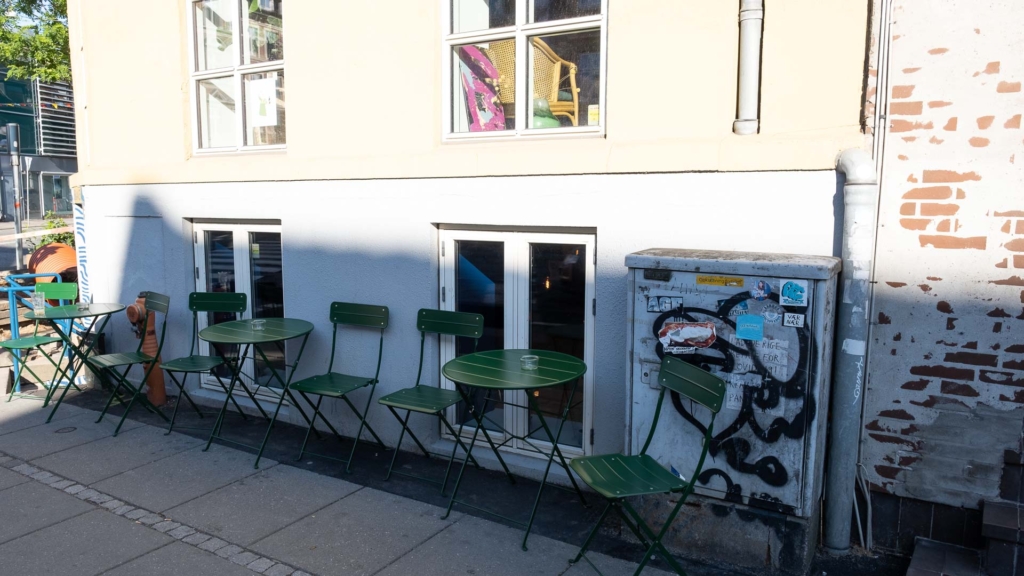 Der er gr&oslash;nne stole og borde p&aring; fortovet ved V&aelig;skebalancen på Frederiksbjerg